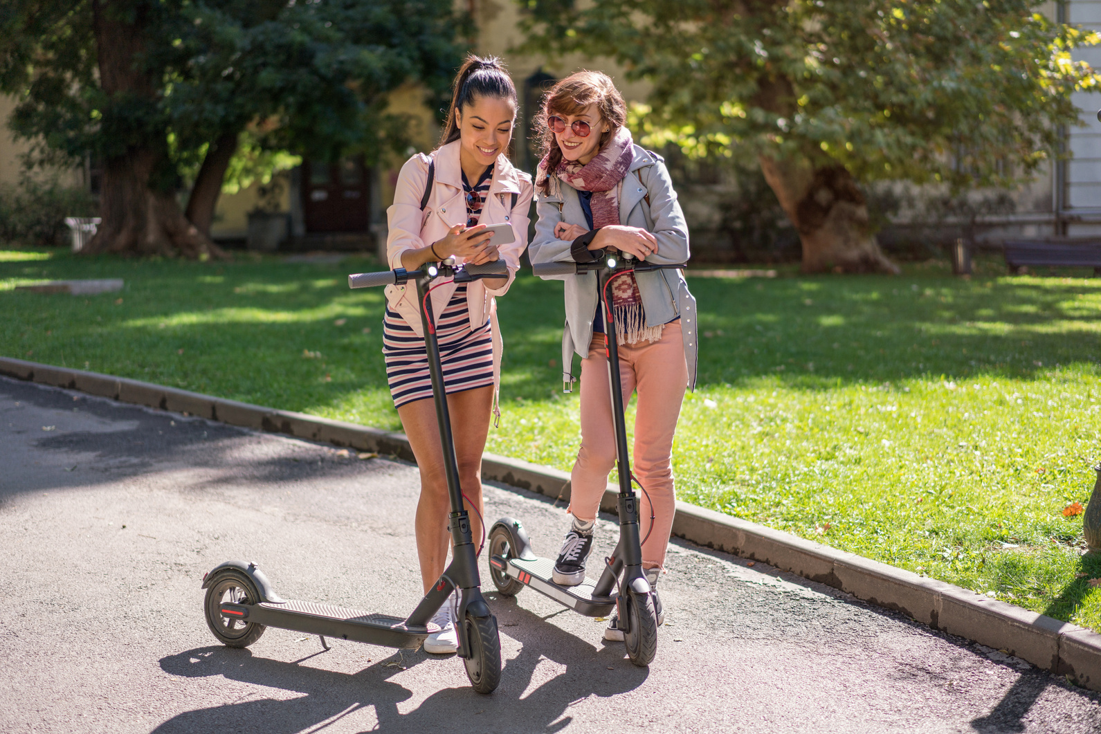 Girls renting e-scooters in the city